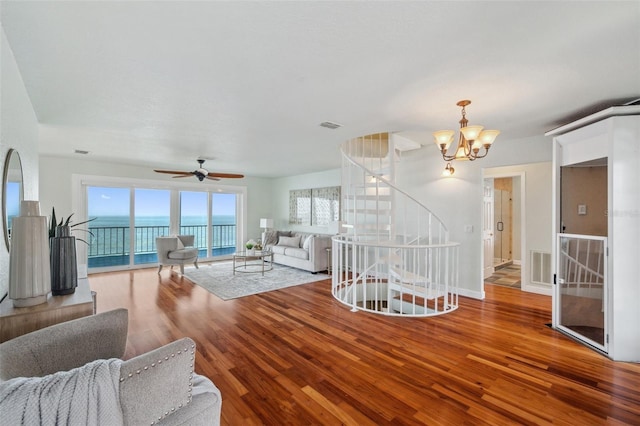6423 Driftwood Dr, Hudson, FL 34667 - living area featuring wood finished floors, a chandelier, a ceiling fan, stairway, and baseboards