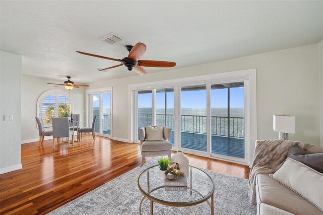 6423 Driftwood Dr, Hudson, FL 34667 - living area featuring wood finished floors, a water view, ceiling fan, and baseboards