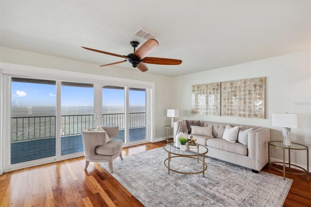 6423 Driftwood Dr, Hudson, FL 34667 - living room featuring a ceiling fan, wood finished floors, baseboards, and a water view