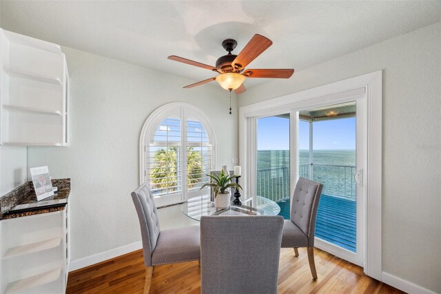 6423 Driftwood Dr, Hudson, FL 34667 - dining space featuring baseboards, a water view, light wood finished floors, and a ceiling fan