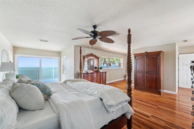 6423 Driftwood Dr, Hudson, FL 34667 - bedroom featuring baseboards, light wood-style floors, access to outside, a textured ceiling, and a ceiling fan