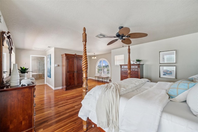 6423 Driftwood Dr, Hudson, FL 34667 - bedroom with light wood finished floors, baseboards, a textured ceiling, ensuite bathroom, and ceiling fan