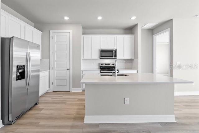 kitchen with white cabinetry, an island with sink, and stainless steel appliances