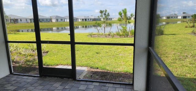 unfurnished sunroom featuring a water view