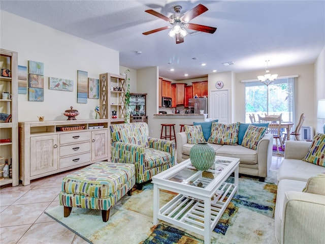 living room with light tile patterned flooring and ceiling fan with notable chandelier