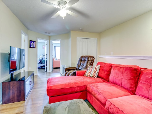 living room featuring ceiling fan and light wood-type flooring