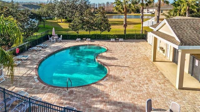 view of pool featuring a water view and a patio