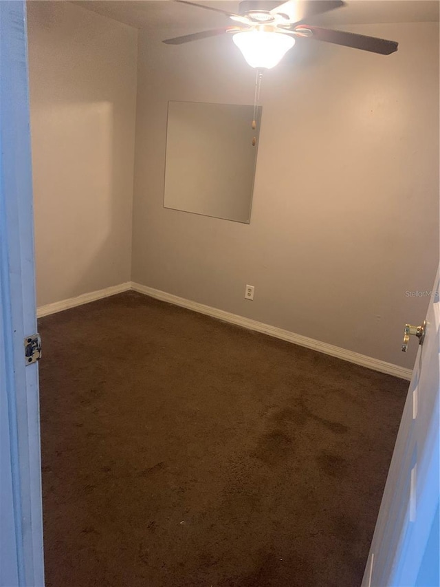 empty room featuring dark colored carpet and ceiling fan