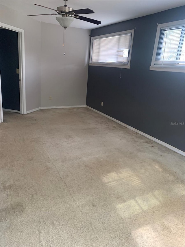 carpeted spare room featuring ceiling fan