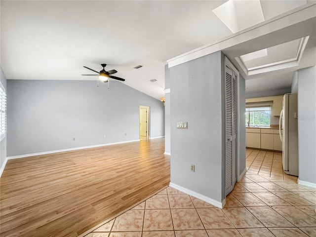 tiled spare room with ceiling fan and vaulted ceiling