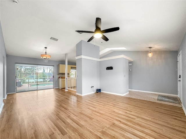 unfurnished living room featuring ceiling fan with notable chandelier, light hardwood / wood-style floors, and lofted ceiling