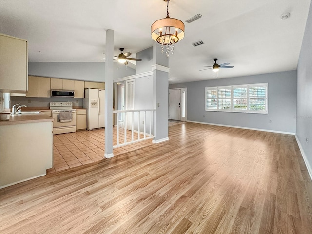 unfurnished living room with ceiling fan with notable chandelier, light hardwood / wood-style floors, lofted ceiling, and sink