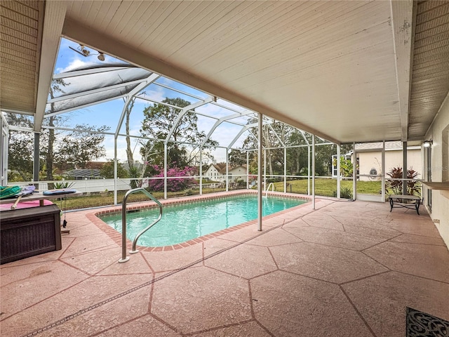 view of swimming pool with a patio and glass enclosure