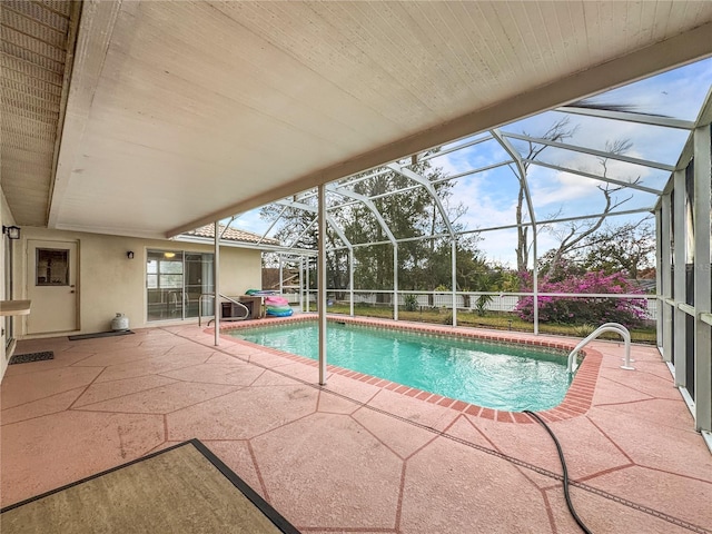 view of pool with a patio and glass enclosure