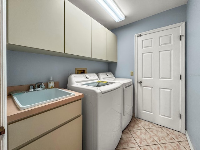 laundry area with separate washer and dryer, sink, light tile patterned floors, and cabinets