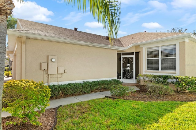 entrance to property featuring a lawn