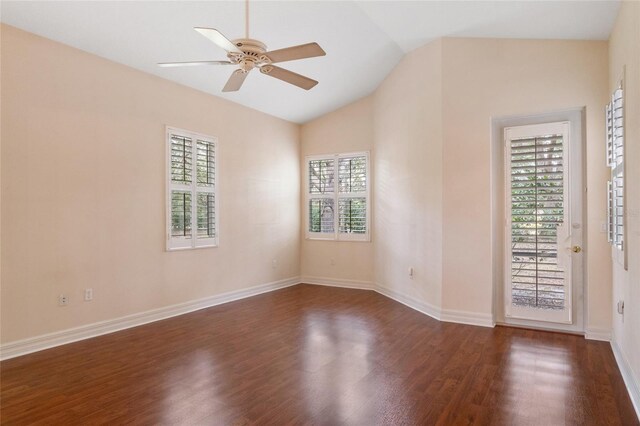 spare room with dark wood-type flooring, lofted ceiling, plenty of natural light, and ceiling fan