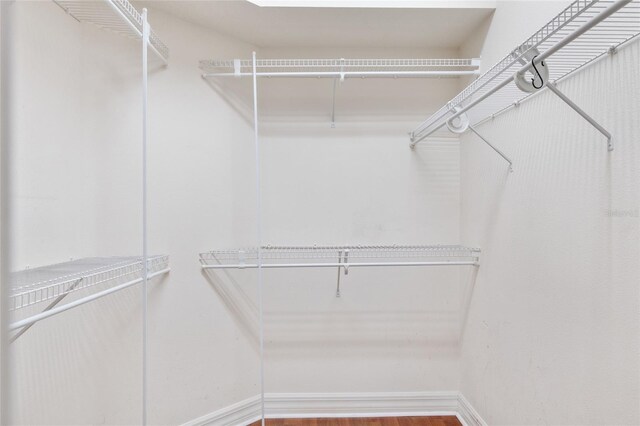 walk in closet with wood-type flooring