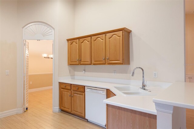 kitchen with light hardwood / wood-style floors, dishwasher, kitchen peninsula, and sink