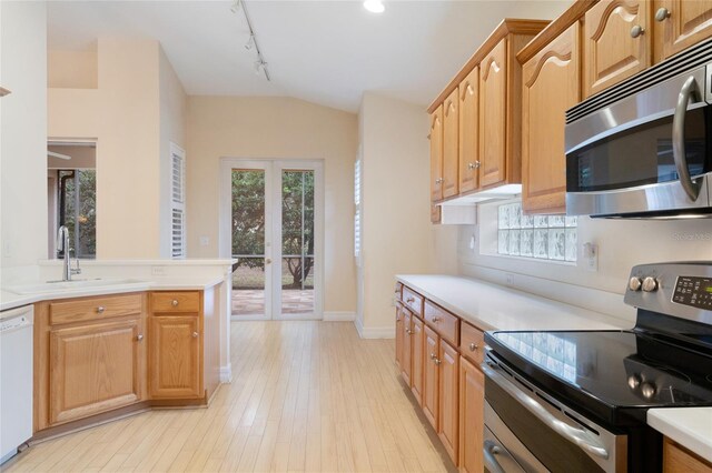 kitchen with sink, light hardwood / wood-style flooring, appliances with stainless steel finishes, french doors, and rail lighting