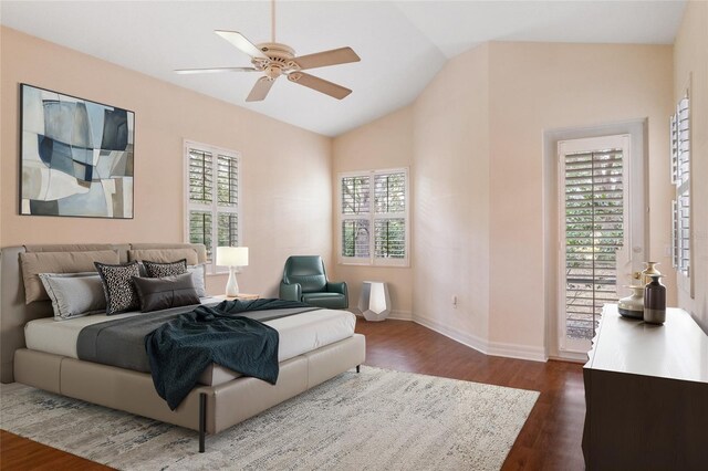 bedroom with vaulted ceiling, ceiling fan, dark wood-type flooring, and multiple windows