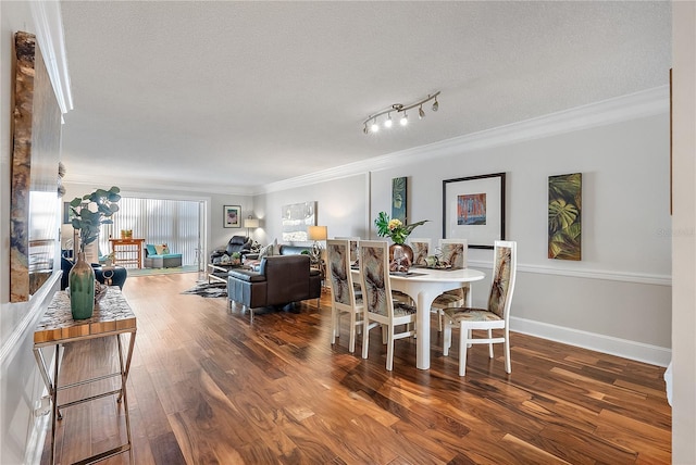 dining area featuring a textured ceiling, crown molding, rail lighting, and dark hardwood / wood-style floors