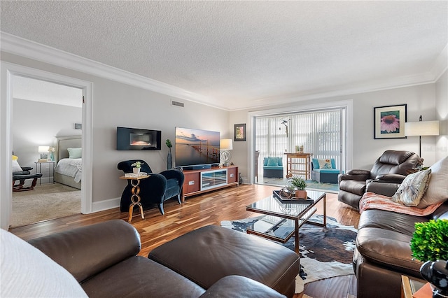 living room with hardwood / wood-style floors, ornamental molding, and a textured ceiling