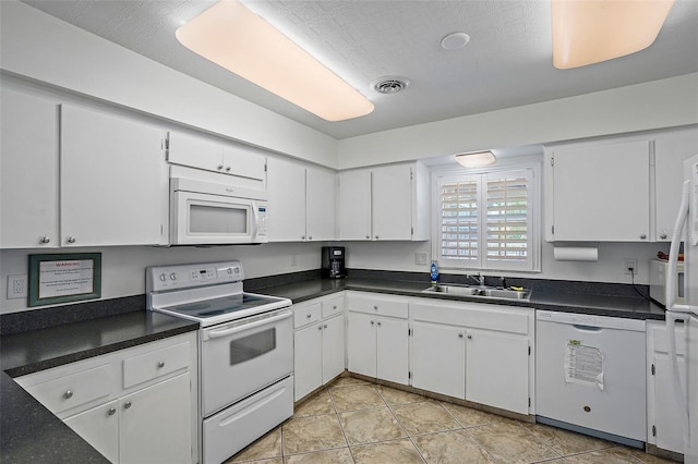 kitchen with light tile patterned floors, sink, white appliances, and white cabinets