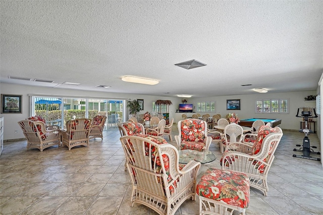 tiled dining room with pool table and a textured ceiling