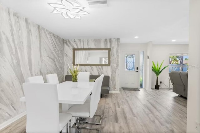 dining space with an inviting chandelier and light hardwood / wood-style floors