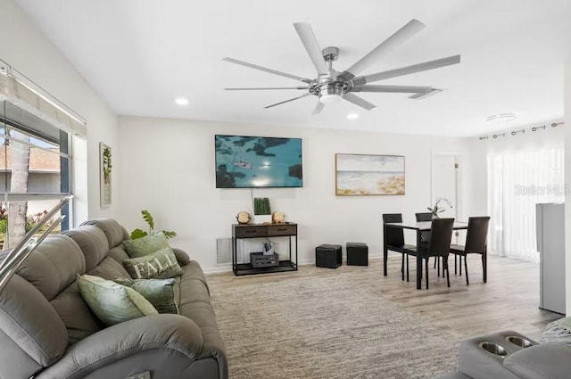 living room featuring ceiling fan and light hardwood / wood-style flooring