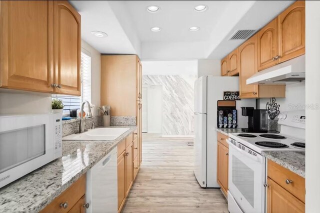 kitchen featuring light wood-type flooring, light stone countertops, sink, and white appliances