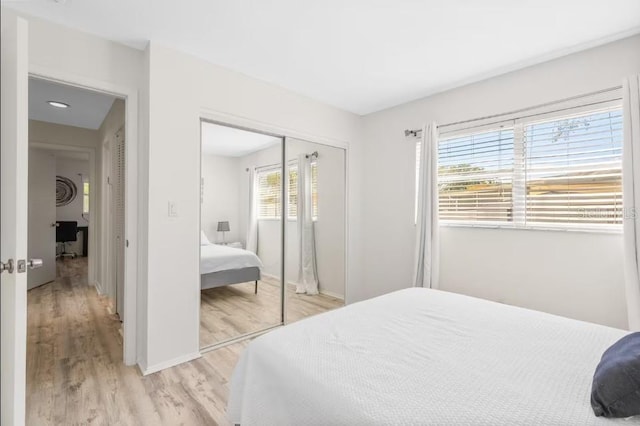 bedroom with light wood-type flooring and a closet