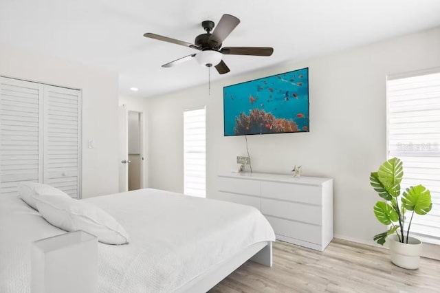 bedroom featuring ceiling fan, a closet, and light hardwood / wood-style flooring