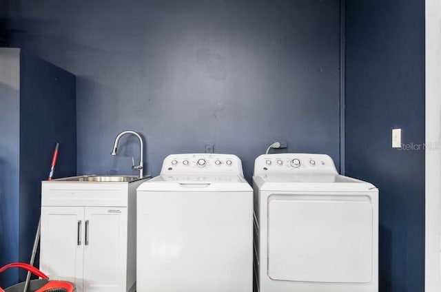 laundry area featuring sink, separate washer and dryer, and cabinets