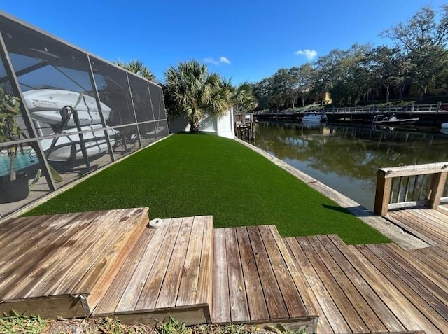 dock area featuring a lanai, a yard, and a water view