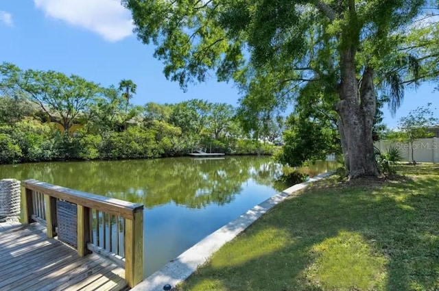 view of dock featuring a water view and a lawn