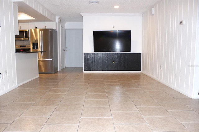 unfurnished living room featuring ornamental molding, a textured ceiling, and light tile patterned floors