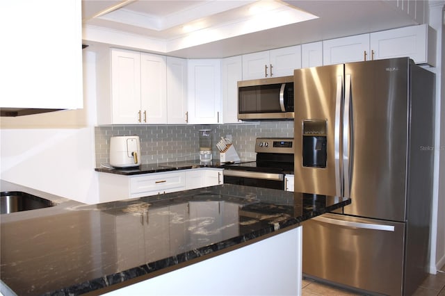 kitchen featuring white cabinetry, stainless steel appliances, dark stone countertops, decorative backsplash, and light tile patterned floors