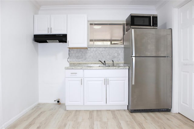 kitchen with white cabinetry, stainless steel appliances, light stone counters, crown molding, and decorative backsplash