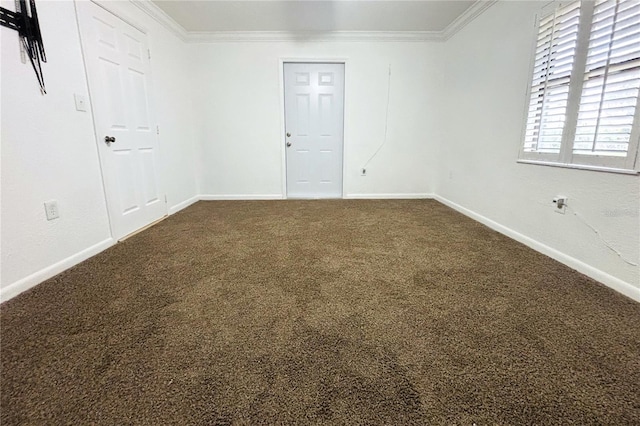 spare room with dark colored carpet and ornamental molding