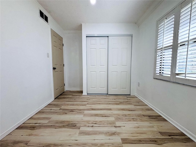 unfurnished bedroom with a closet and light wood-type flooring