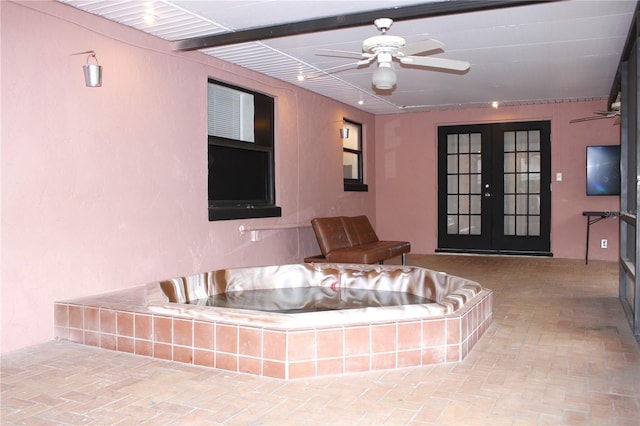 unfurnished living room with ceiling fan and french doors