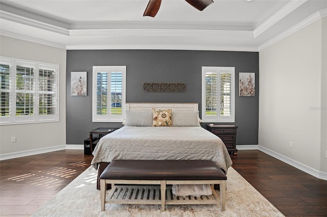 bedroom with ceiling fan, dark wood-type flooring, a raised ceiling, and crown molding