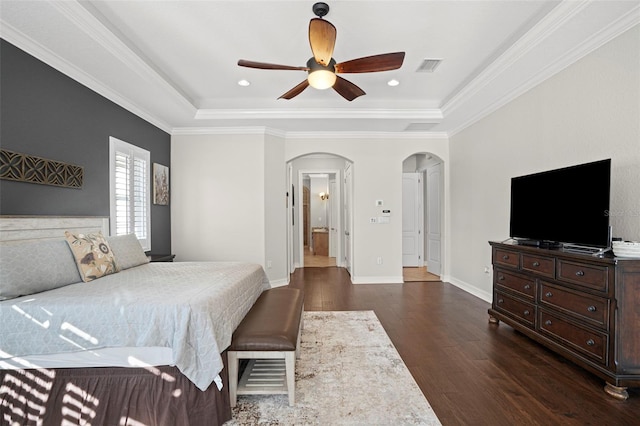 bedroom with ceiling fan, a raised ceiling, crown molding, and dark hardwood / wood-style floors