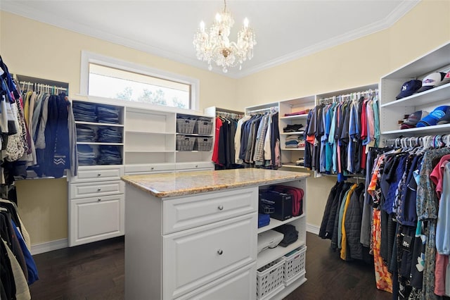 walk in closet featuring a notable chandelier and dark hardwood / wood-style floors