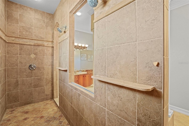 bathroom featuring ornamental molding, tiled shower, and vanity