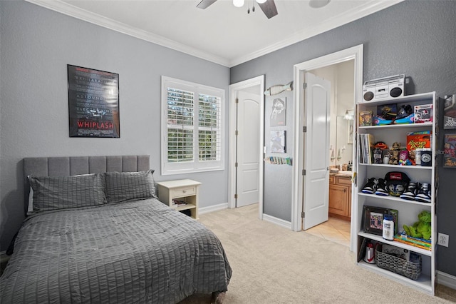 bedroom featuring ceiling fan, light colored carpet, ornamental molding, and ensuite bath