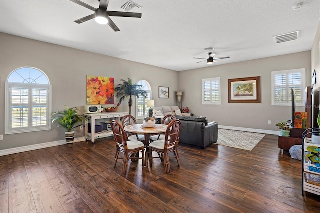 dining space featuring a textured ceiling, ceiling fan, a healthy amount of sunlight, and dark hardwood / wood-style floors