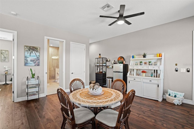 dining room featuring ceiling fan, dark wood-type flooring, and a textured ceiling